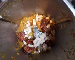 Step <p>Le agregamos el chorizo, 60 g de alubias previamente aclaradas y escurridas, el pimentón, la pastilla de caldo, el comino, el laurel y el agua.</p> illustration