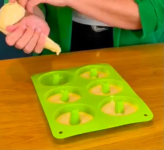 Step Ponemos la masa en una manga pastelera y rellenamos los huecos de un molde de dónut. Hornear 18-20 minutos a 180 grados con calor arriba y abajo.
Dejar enfriar illustration